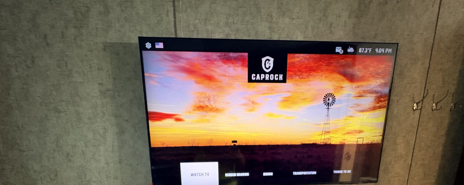 Wall-mounted guest TV after a volume hang in a man-camp room
